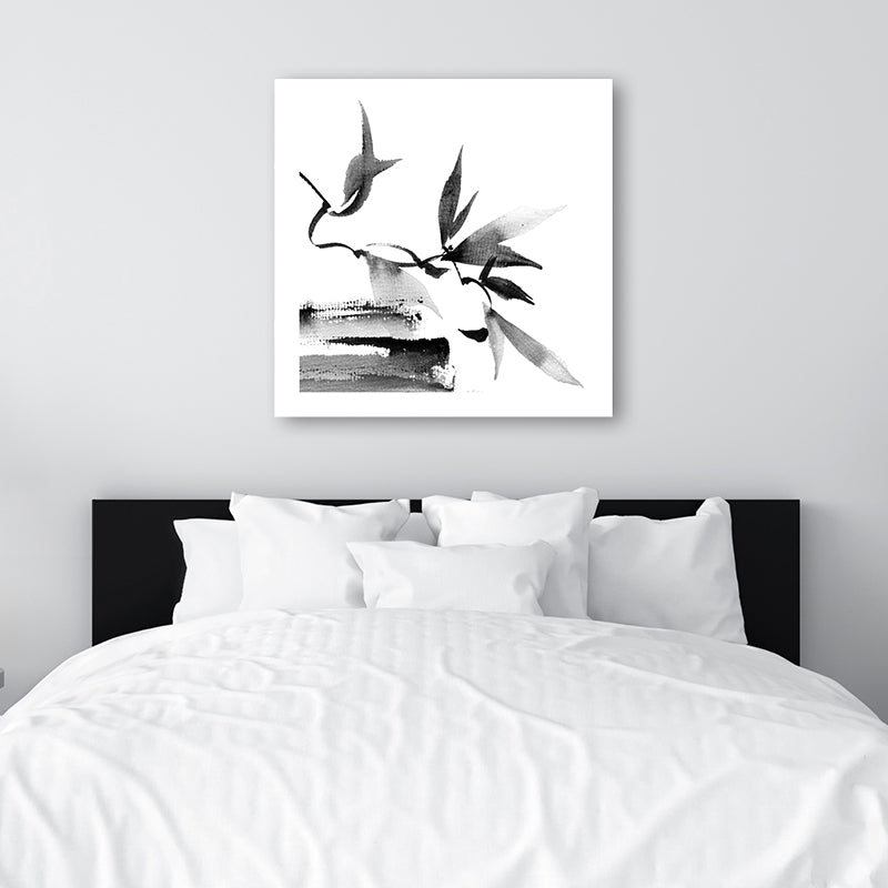 Black and white Japanese-style wall art print of twigs and leaves, in a monochrome, minimalist bedroom.