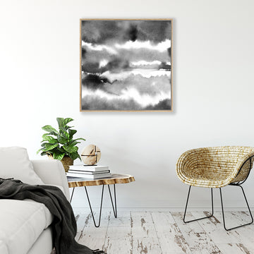 Abstract black and white framed art print with black watercolour washes resembling clouds in a bohemian interior.