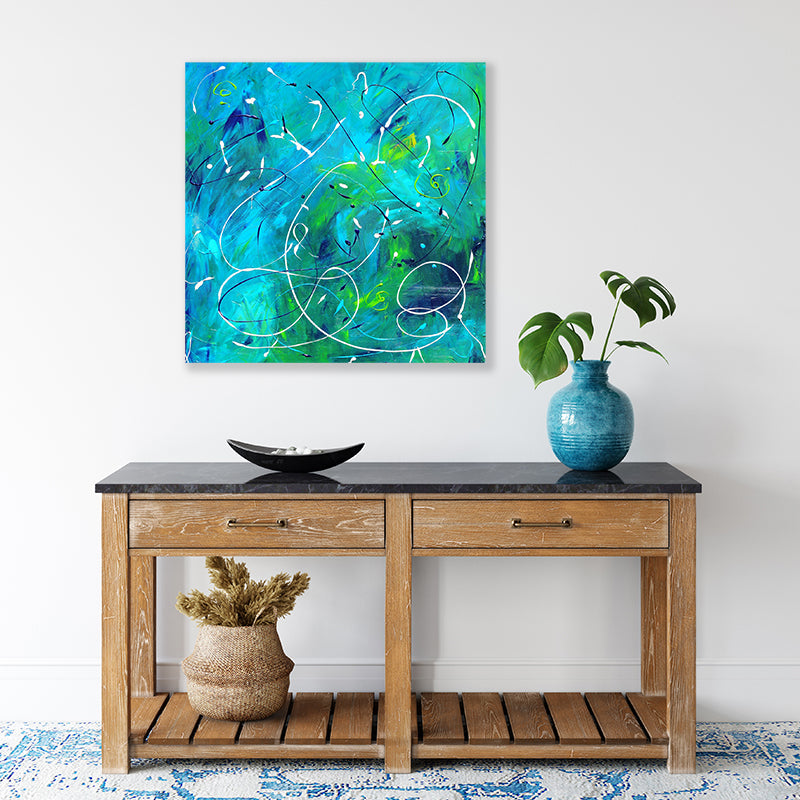 Abstract canvas art print depicting underwater currents in an aqua sea, displayed in a coastal-style interior.