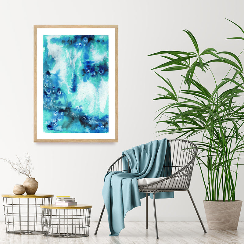 Abstract framed art print in shades of aqua and sapphire blue, displayed in a minimalist tropical-style interior.
