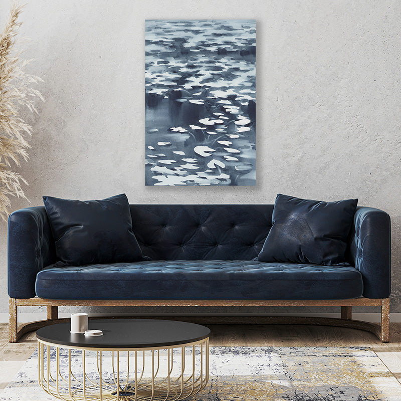 Inky black and white canvas wall art print of a moonlit waterlily pond above a midnight-blue velvet couch.