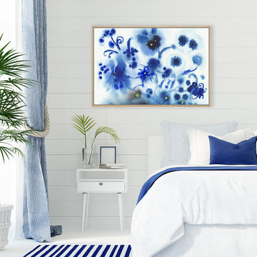 Wall art print of navy blue flowers, produced by ink droplets, in a blue and white Hamptons-style bedroom.