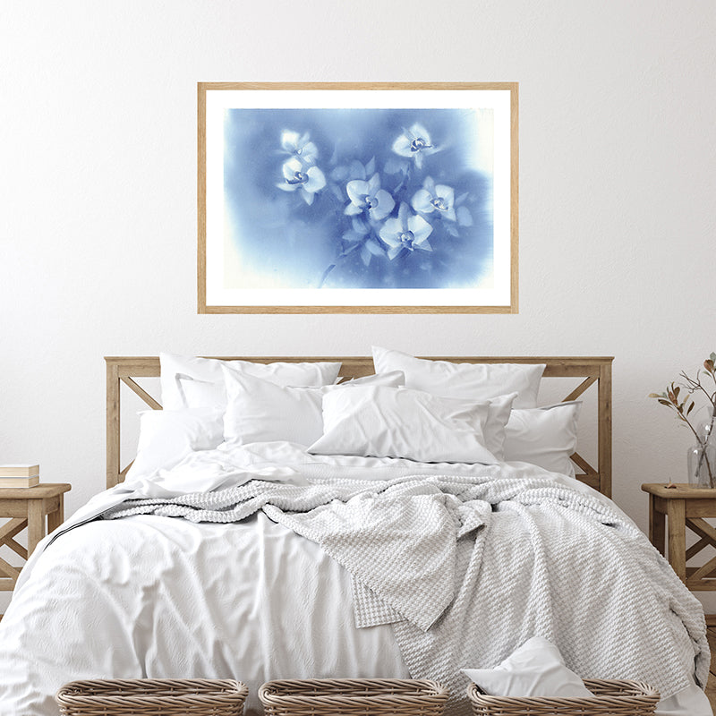 Framed art print depicting white orchids against a dusky blue moonlit sky displayed in a farmhouse-style bedroom.