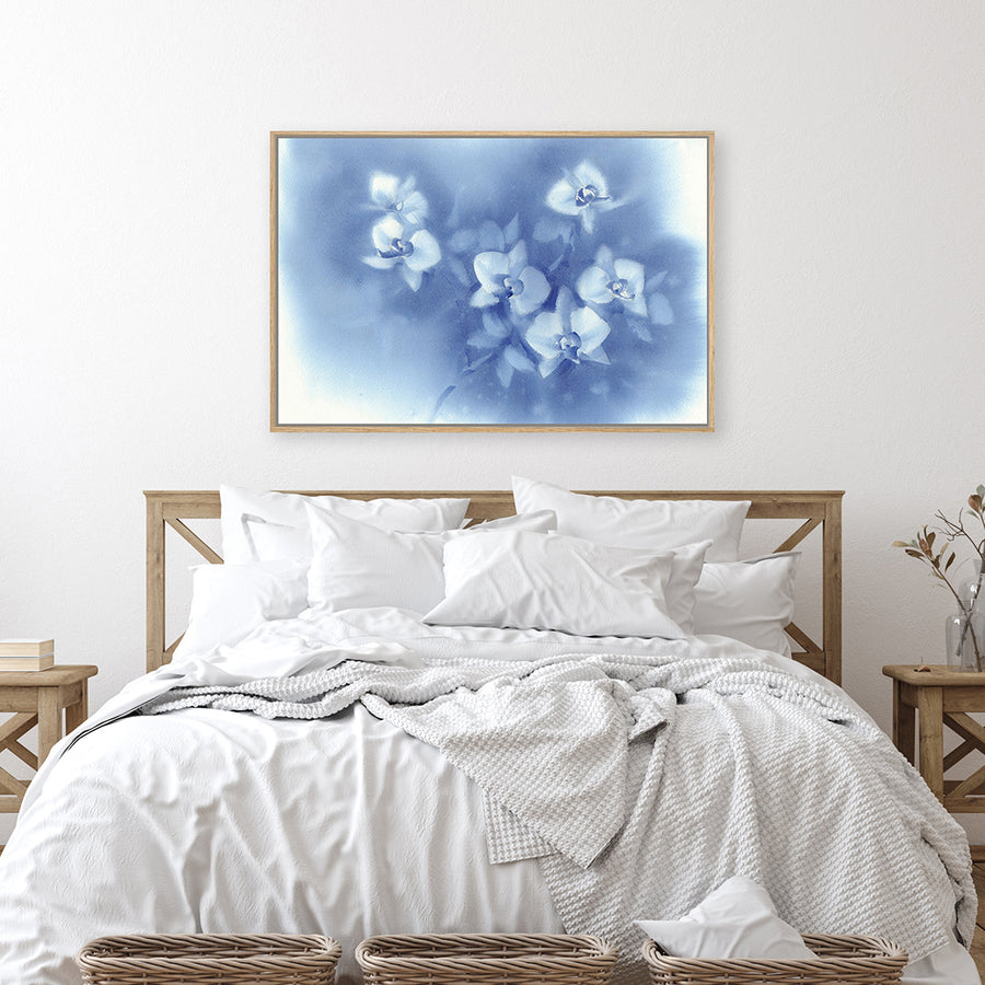 Wall art print depicting white orchids against a dusky blue moonlit sky displayed in a farmhouse-style bedroom. 
