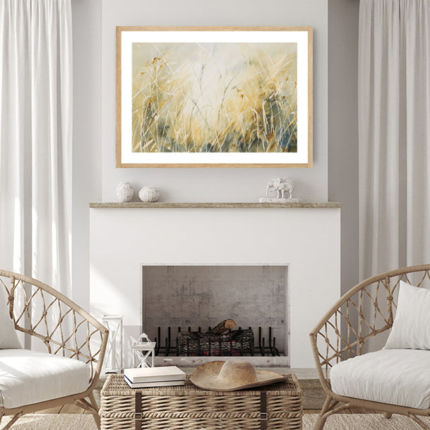 Framed art print of that captures sunlight filtering through dried grass, showcasing tan hues, in a beige living-room.  