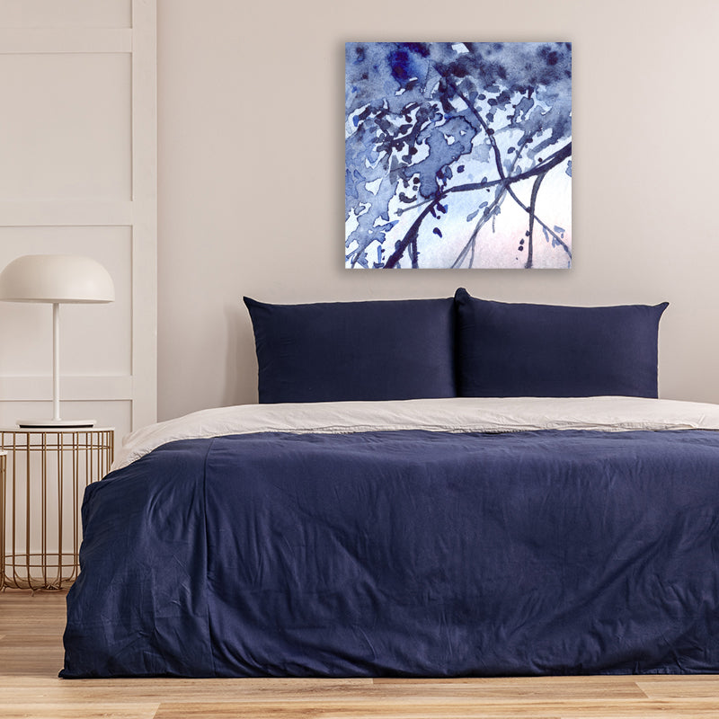 Indigo-blue abstract art print depicting branches in the moonlight, in a bedroom with navy blue and white decor