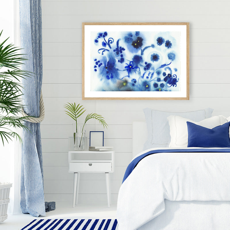 Framed art print of navy blue flowers, produced by ink droplets, in a blue and white Hamptons-style bedroom.