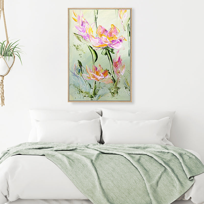 Canvas art print of pink flowers and olive green foliage, displayed in a soft-green and white minimalist bedroom.