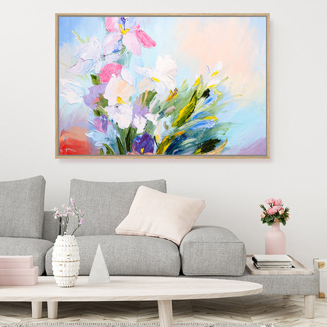 Impressionist floral framed canvas art print in white, pink and mauve, with a blue sky background., in a pale grey scandinavian style living room.