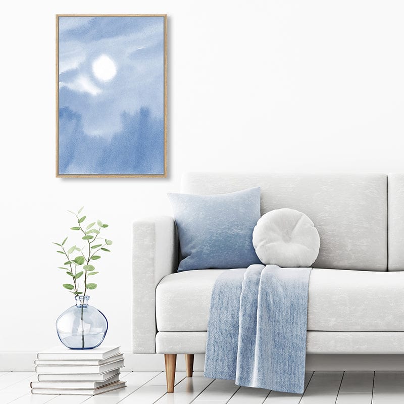 Canvas watercolour art print of pastel blue sky with the sun breaking through clouds in a pale blue, grey and white minimalist interior.