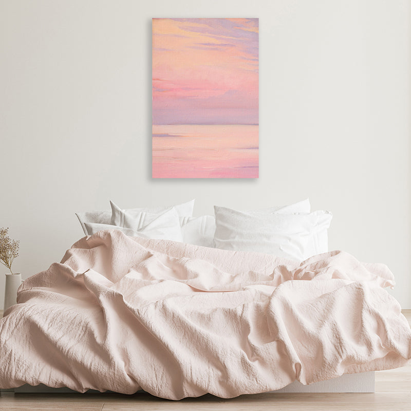 Canvas art print of a lavender pink sky reflected in a calm sea in a minimalist white and pastel pink bedroom.