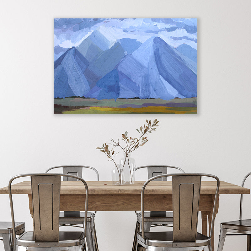 Abstract expressionist canvas art print of denim blue mountains beneath a cloudy sky in a modern farmhouse style dining room.